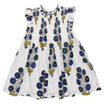 The Pink Chicken Girls' Stevie Dress features a white sleeveless design with ruffled shoulders, hand-smocked details, and a Navy Buttercup Floral blue and yellow print.