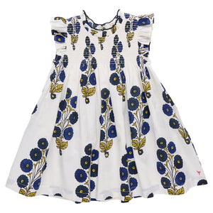 The Pink Chicken Girls' Stevie Dress features a white sleeveless design with ruffled shoulders, hand-smocked details, and a Navy Buttercup Floral blue and yellow print.