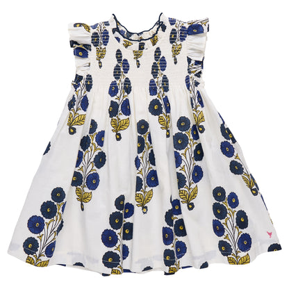 The Pink Chicken Girls' Stevie Dress features a white sleeveless design with ruffled shoulders, hand-smocked details, and a Navy Buttercup Floral blue and yellow print.