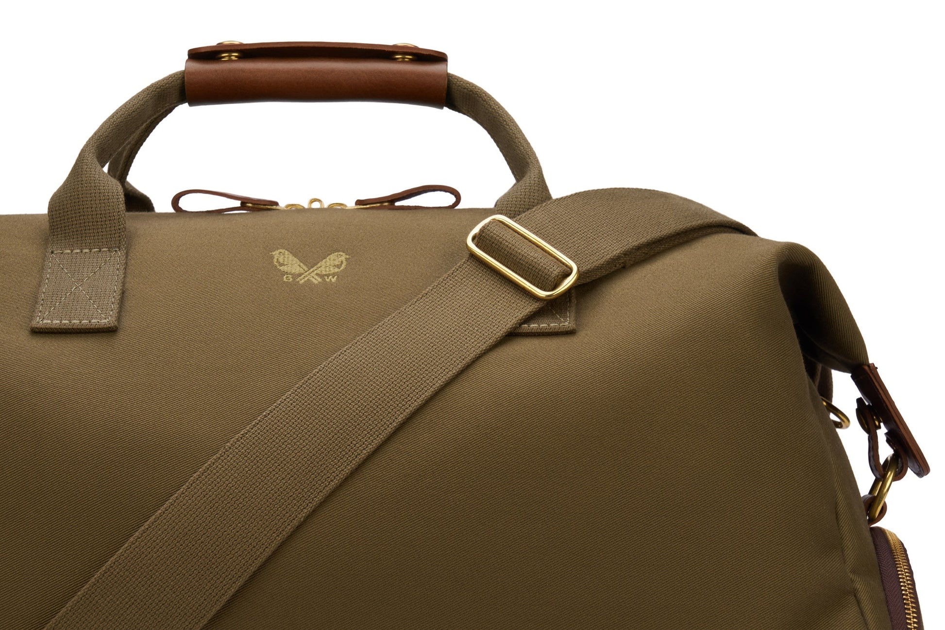 The Bennett Winch Canvas Weekender is a bag made with green waterproof canvas, featuring brown full-grain leather handles and a gold buckle on the strap.