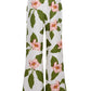 The Cara Cara Sunflower Pant features a green and pink floral print with large leaves and flowers. These white wide-leg pants offer a tailored, fresh, and vibrant look, displayed against a plain background.