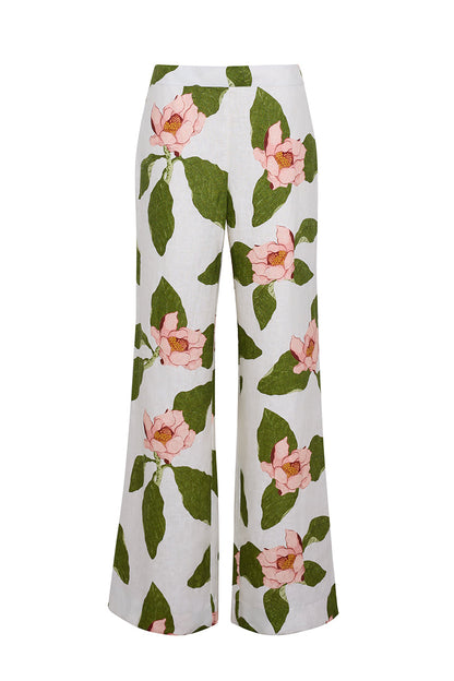 The Cara Cara Sunflower Pant is a tailored white wide-leg style showcasing a large pink floral and green leaf print.