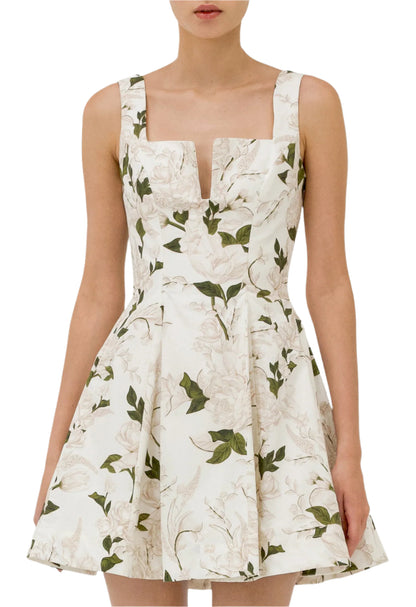 A person wearing the Agua Dress by Agua By Aguabendita, a sleeveless ivory A-line dress featuring a floral print and a feminine sweetheart neckline.