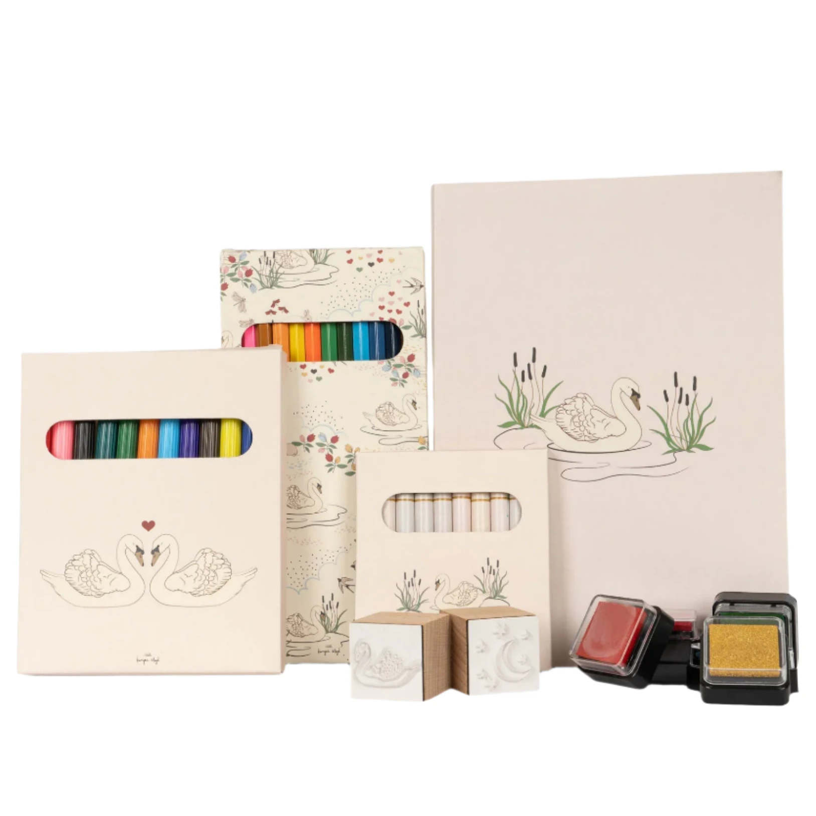 The Konges Slojd Artist Set from Kongas Slojd is a creative kit including colored pencils, crayons, stamps, and notebooks with swan illustrations, all packed in a charming suitcase.