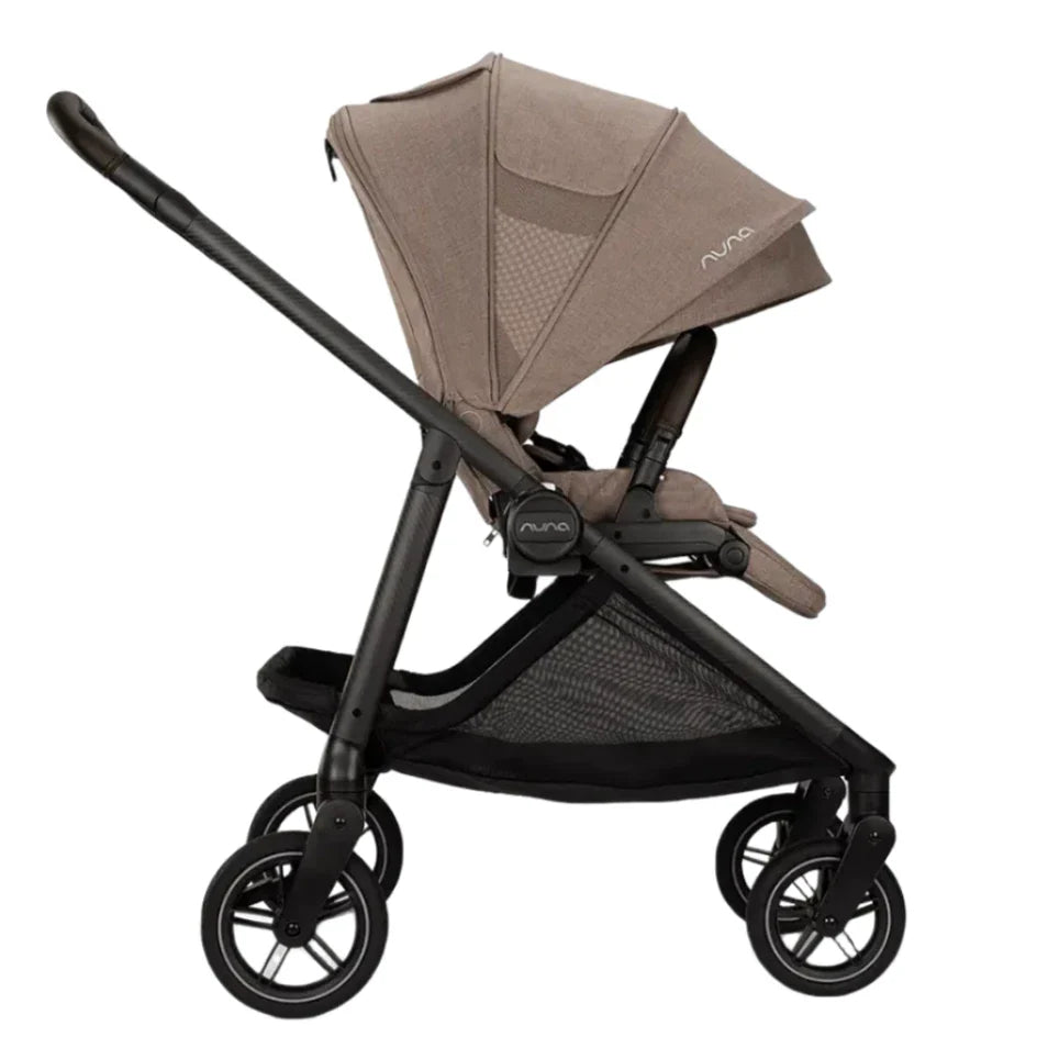 Side view of the beige Nuna SWIV Stroller by Nuna with a black frame, featuring a canopy, storage basket, and four button-activated rotation wheels.