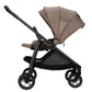 Side view of the beige Nuna SWIV Stroller with a black frame, showcasing its four 360-degree swivel wheels, sunshade canopy, and an under-seat storage basket.