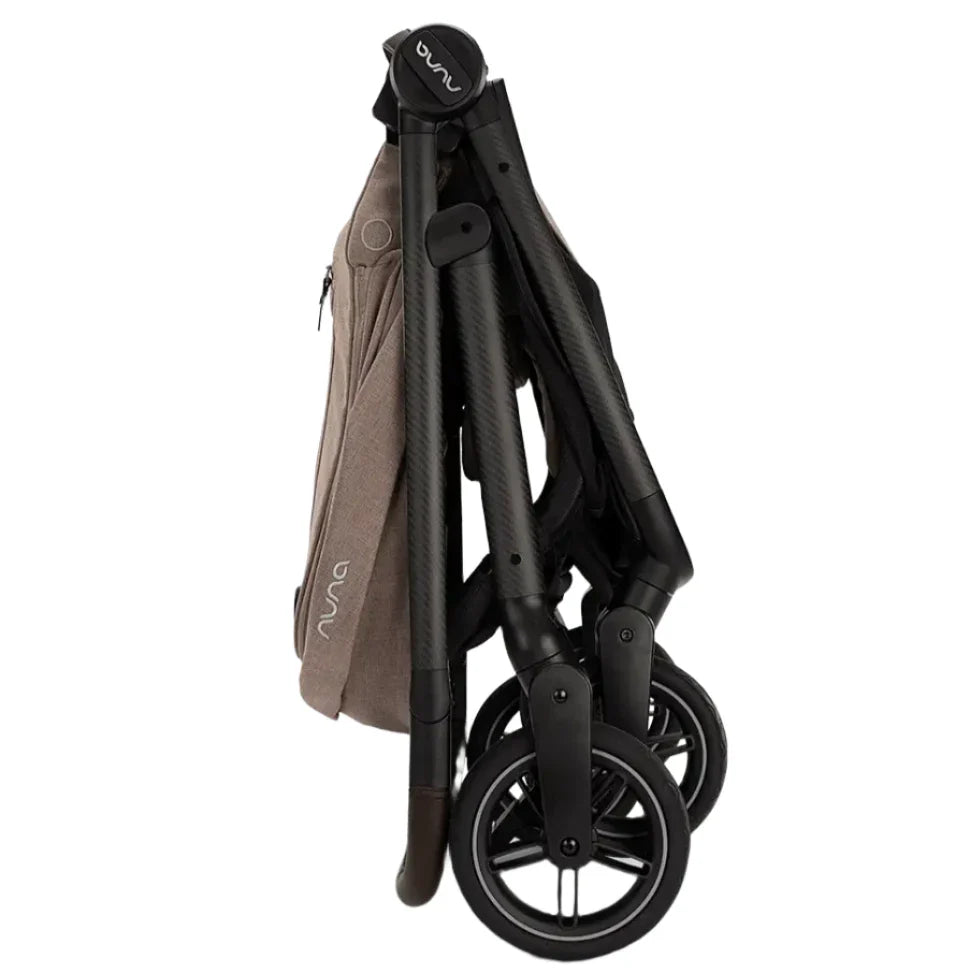 The Nuna SWIV Stroller by Nuna is designed to fold into a vertical position, boasting black handles and 360-degree swivel wheels, and featuring beige fabric accents.