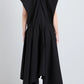 A person is seen from the back wearing the Sybella Dress by Proenza Schouler, a sleeveless black design featuring a handkerchief hem and flowing silhouette, set against a plain light background.