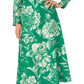 A person is wearing the Monique Lhuillier Long Sleeve Floral Day Dress, featuring a green floral print and jewel neckline, paired with nude heels.