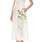 A woman wears the Monique Lhuillier Iris Printed Poplin Day Dress, featuring short sleeves, a button-down front, belted waist, and styled with white high-heeled sandals.