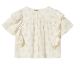 The Cozmo Girls' Tansy Floral Blouse is a white, short-sleeved top crafted from soft cotton gauze, featuring delicate floral embroidery, back buttons, ruffled sleeves, and a round neckline.
