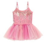 The Girls’ Bebe Shirley Sparkle Tutu by Tutu du Monde is a peach blush tutu dress for little girls, featuring a pink sleeveless design with a sequined bodice, delicate thin straps, and a layered tulle skirt in various shades of pink.