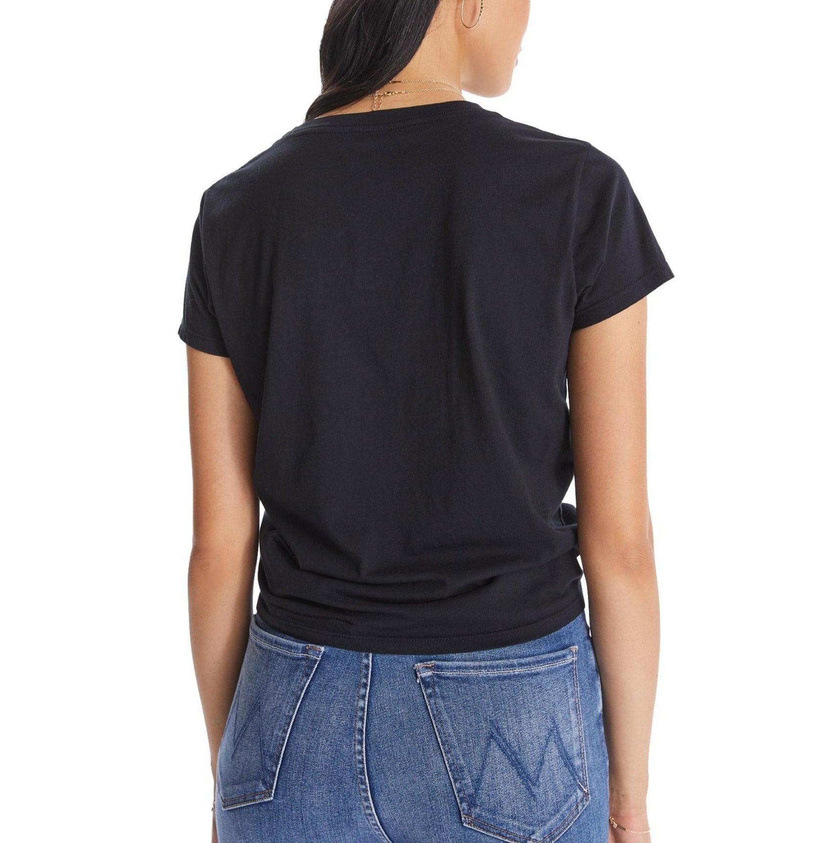 A woman seen from behind wearing a black Mother Denim Lil Goodie Goodie Tee and blue denim jeans.