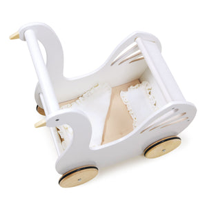 The Sweet Swan Pram by Tender Leaf Toys is a white wooden stroller shaped like a swan, featuring wooden wheels and ruffled bedding inside. Viewed from above, this charming buggy makes a whimsical wooden toy pram perfect for imaginative play.