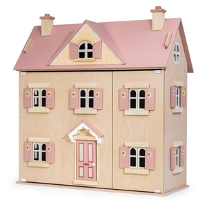 The Alouette House by Tender Leaf Toys is a wooden plywood dollhouse with a pink roof, chimneys, shutters, and a front door, featuring charming floral details on the window shutters against a plain background.