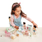 A young girl in a cat ear headband plays with the Countryside Furniture Set by Tender Leaf Toys, carefully arranging its miniature furniture and accessories on a light-colored table.