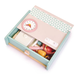 The Tender Leaf Toys Kitchenette features a wooden toy microwave with a clock dial, two buttons on top, and an assortment of play food items stored in a drawer beneath—ideal for creating a portable kitchenette setup that sparks imaginative play. Pair the Kitchenette with wooden utensils to complete your child’s pretend-cooking experience.