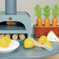 The Tenderleaf La Fiamma Grand Kitchen by Tender Leaf Toys features a toy kitchen with wooden lemons in a bowl, toy carrots in a planter, a triangular food piece, and wooden logs. Complete with a pretend cooking stove and pizza oven, this set has all the accessories your little chef needs for imaginative play.