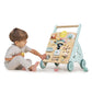 A toddler sits on the floor playing with a Tenderleaf Sunshine Baby Activity Walker, ready to take their first steps.