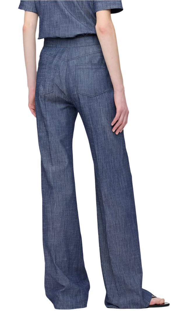 A person wearing the Tonne Pant from Callas Milano, featuring a stretch denim design with short sleeves and wide-leg pants, is standing facing away from the camera.