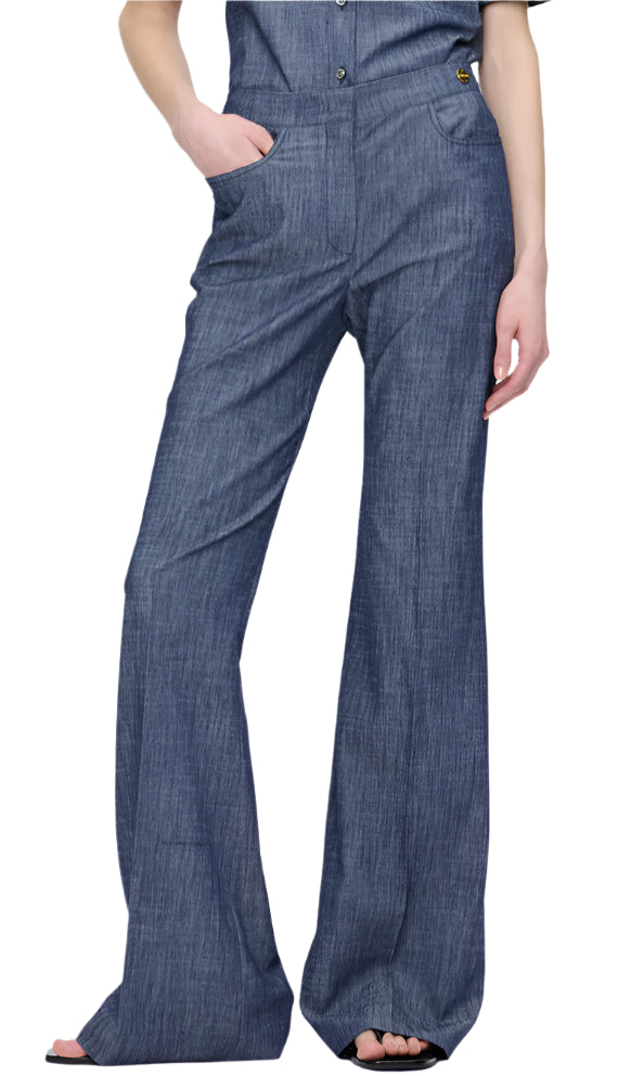 Wearing Callas Milano's Tonne Pant, a person showcases a stylish high-rise trouser look with hands casually in pockets against a plain white background.