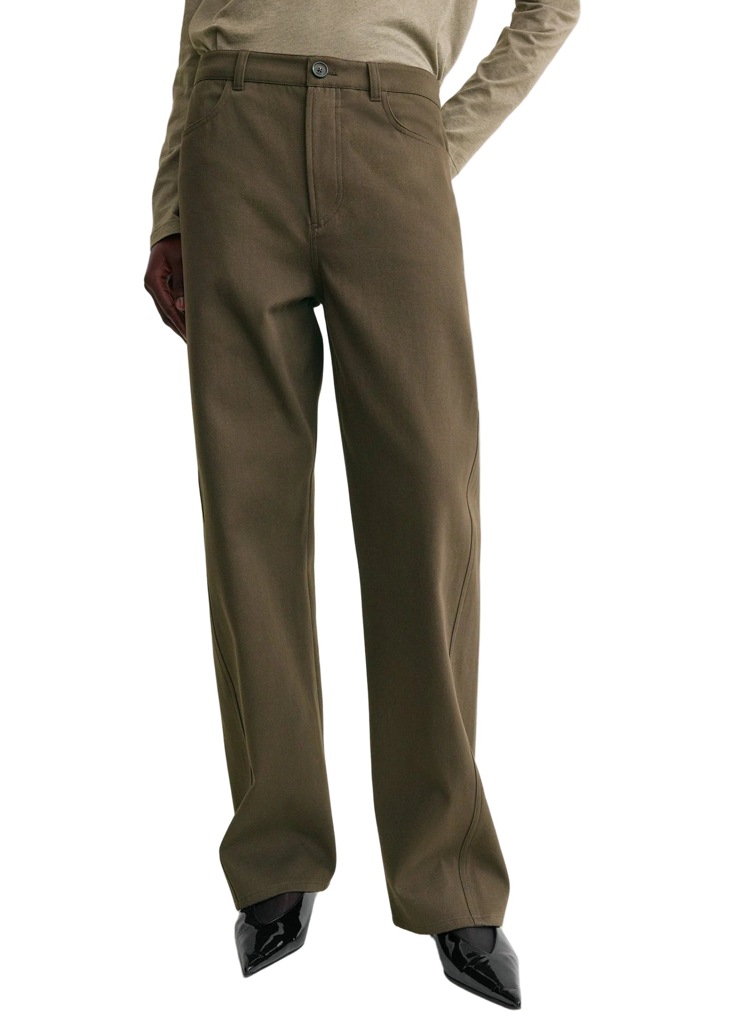 A person wearing Toteme Twisted Tailored Trousers in olive green with black pointed shoes and a beige long-sleeve top. The image is cropped from the chest down.