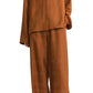 Person wearing the Toteme Monogram Silk PJ Top in rust, a loose-fitting blouse in silk twill with geometric monogram pattern, paired with matching pants and facing forward.
