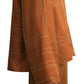 A person models the Toteme Monogram Silk PJ Top in orange, featuring white geometric stitching and a subtle monogram pattern, shown from shoulder to knee against a white background.