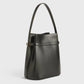 The Toteme Belted Bucket Bag, crafted from black Palmellato leather with a single shoulder strap and minimalistic design, stands upright against a plain white background.