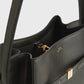 Close-up of a black Toteme Belted Bucket Bag with gold hardware and visible internal compartments, showing the "TOTEME MADE IN ITALY" stamp.
