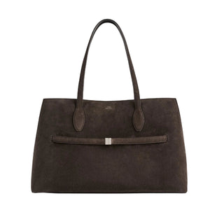 The Toteme Suede Lounge Tote is a spacious, dark brown Italian suede bag with dual handles and a slim horizontal strap with a metallic accent—ideal for everyday use.
