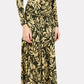 A person wearing a long-sleeve, ruched olive green and beige floral dress paired with the Ulla Johnson Fiona Jersey Skirt, tan socks, and beige shoes with large brown tassels stands against a plain background.