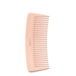 A small AERIN Travel Pink Pastel Comb by Aerin, handcrafted in Italy with wide teeth, laying on a white background.