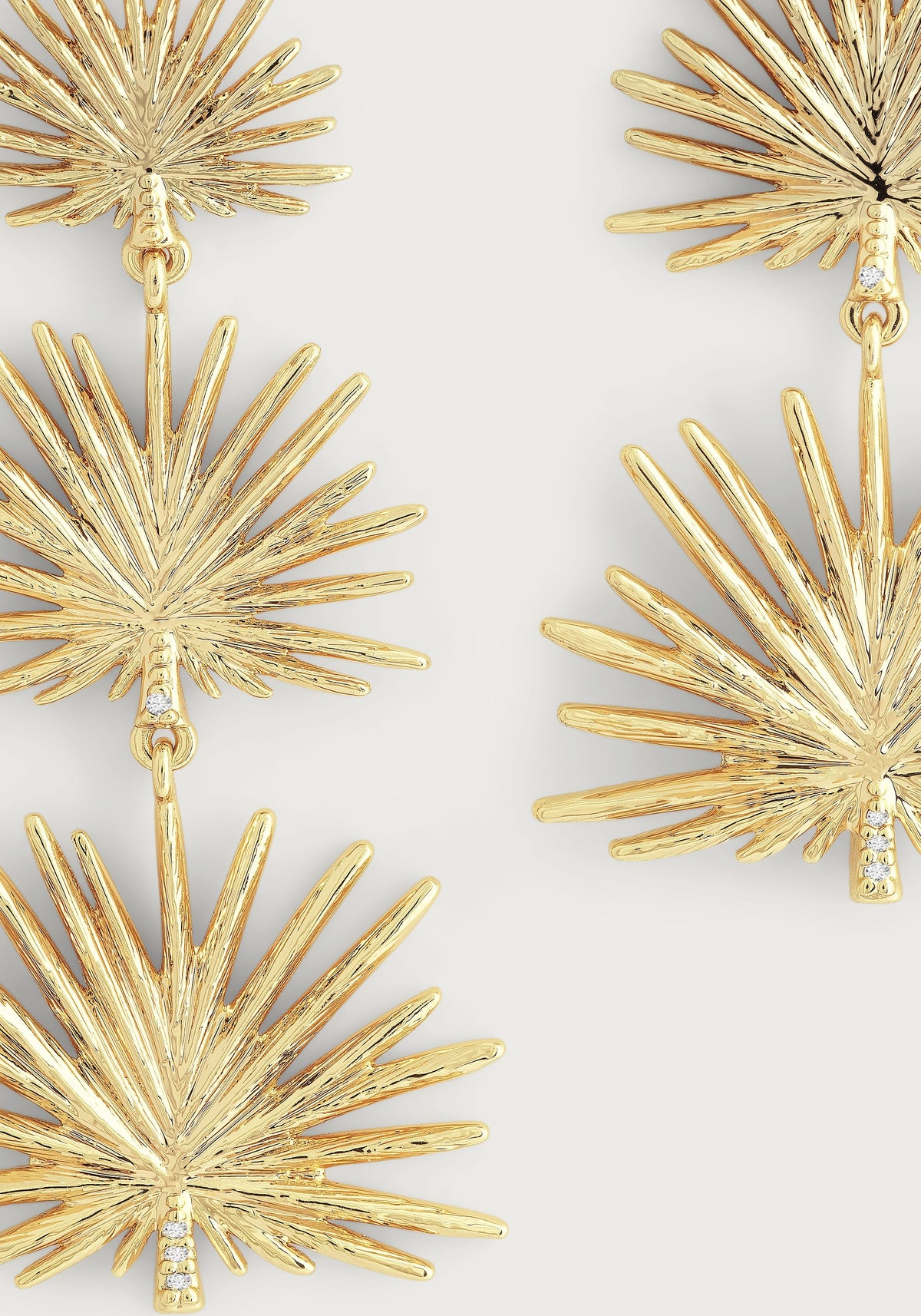 Anabel Aram Palm Triple Fan Dangle Earrings in 18K gold plate, featuring three stacked, textured fan-shaped palm leaf charms accented with small inset crystals.