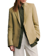 A person with long hair wearing the TWP Husband Linen Jacket in beige, seen from the back.