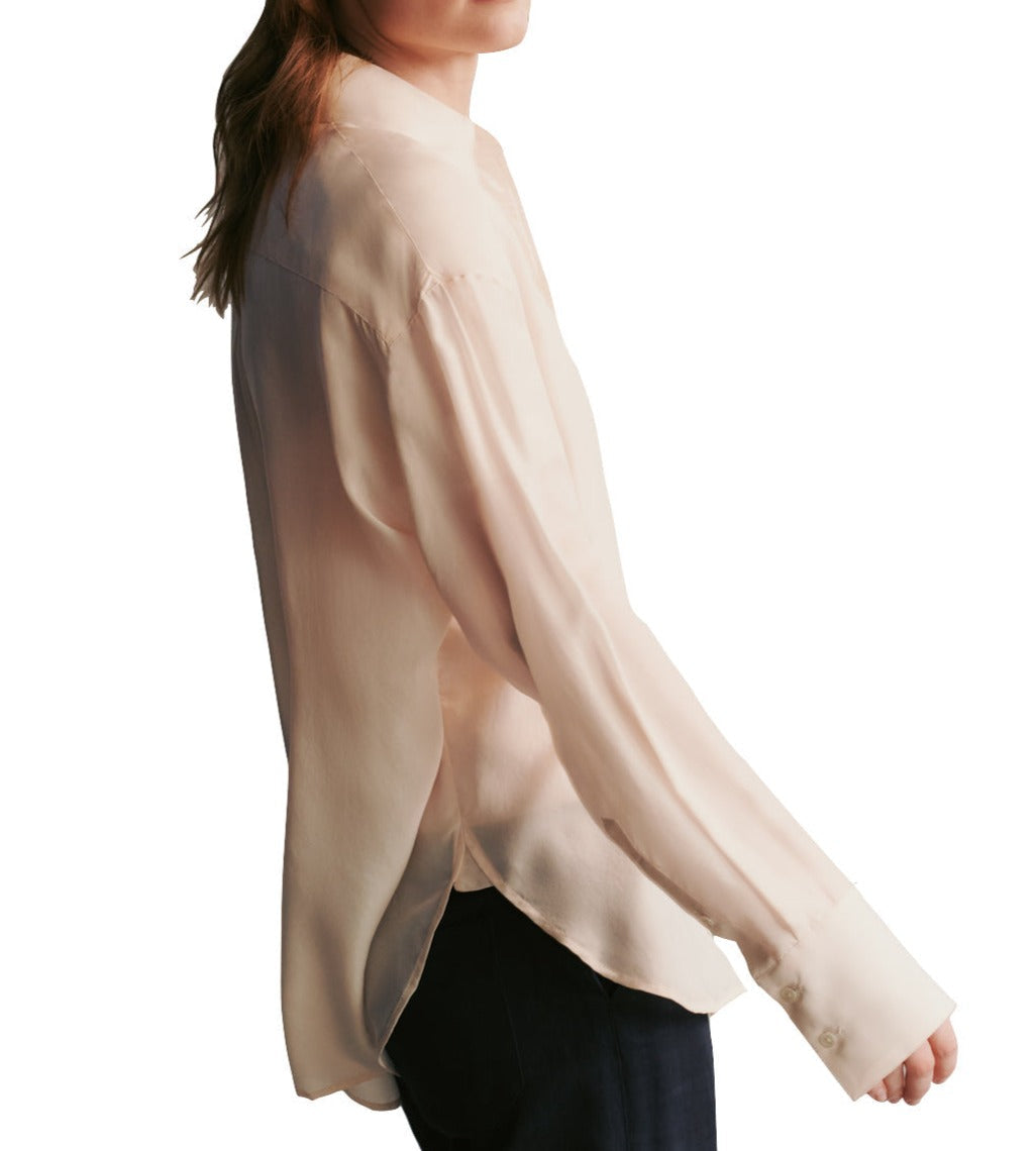 Person wearing a light beige, textured feel TWP Big Joe Silk Top by TWP and dark pants, shown from the waist up, facing sideways.