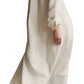 A person wearing the TWP Jenny's Coated Linen Gown with a point collar and green high heels is walking away from the camera.
