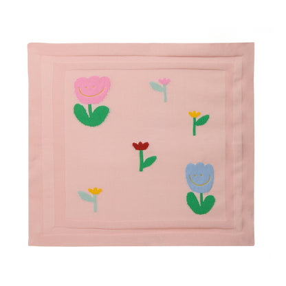 The Stella McCartney Kids Baby Knit Floral Blanket is a pink, lightweight baby blanket with a border and cheerful flower designs in pink, blue, yellow, and red at the center.