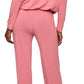 A woman stands barefoot, seen from the back, wearing the Eberjey EBJ Gisele Slouchy Set—a long-sleeved, loose-fitting pink loungewear set crafted from sustainable TENCEL™ Modal.