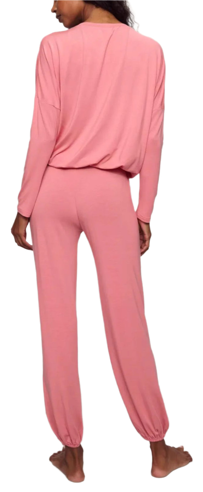 A woman stands barefoot, seen from the back, wearing the Eberjey EBJ Gisele Slouchy Set—a long-sleeved, loose-fitting pink loungewear set crafted from sustainable TENCEL™ Modal.