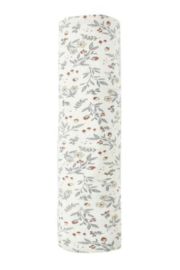 The Quincy Mae Bamboo Swaddle is a soft bamboo fabric baby wrap, white with a pattern of small, scattered flowers and leaves in muted colors.
