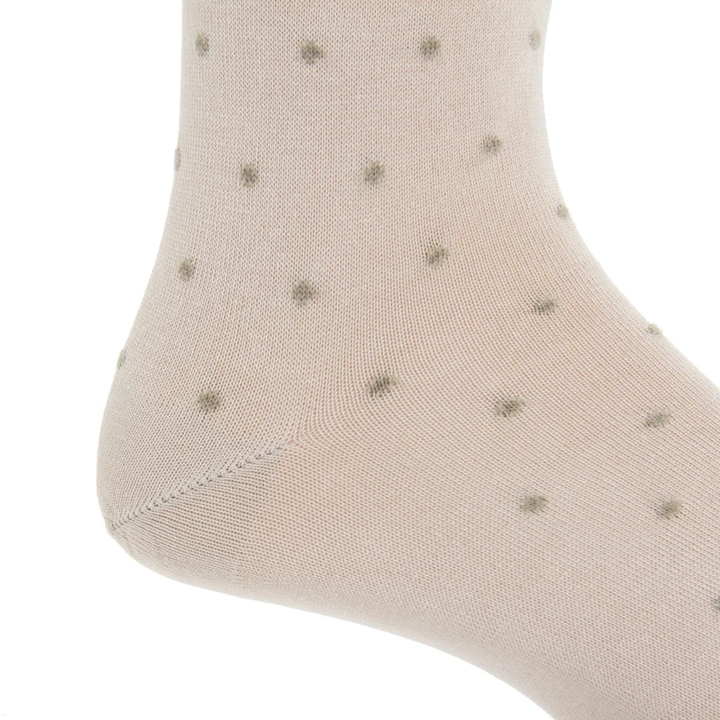 Close-up of a light beige Dapper Classics Dot Cotton Mid Calf Sock featuring small, evenly spaced gray polka dots, highlighting the heel and ankle area—an elegant option for men’s dress socks.