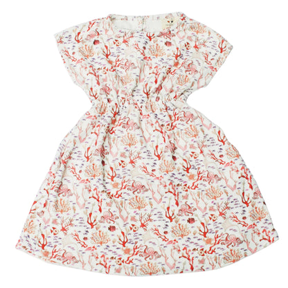 The Delphine Dress by Timo & Violet is a playful summer dress for baby girls and girls featuring short sleeves, organic cotton, and a vibrant Rosy Coral Reef print with a gathered waist and round neckline.