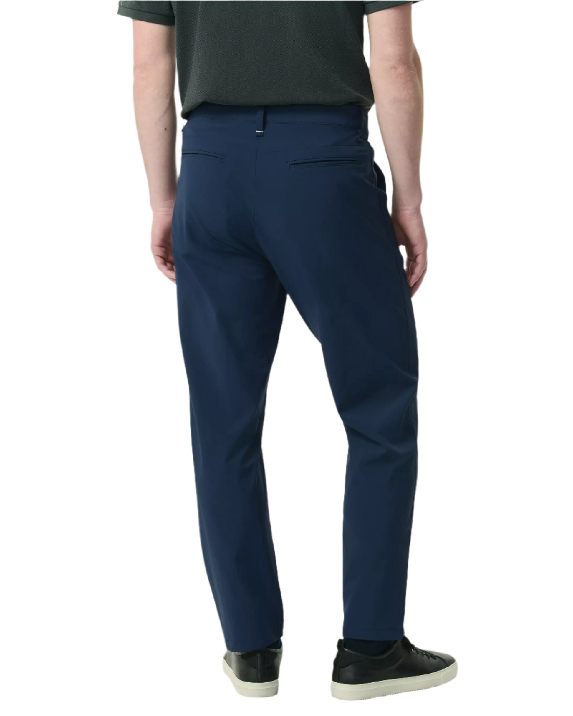 A person wearing Rag & Bone Tapered Nylon-Blend Trouser in navy, a dark shirt, and black sneakers stands facing away against a white background.