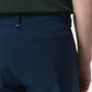 Close-up of a person wearing Rag & Bone's Tapered Nylon-Blend Trouser in dark blue, paired with a dark green shirt, showcasing the waistband, belt loop, and back pocket details on these streamlined pants.