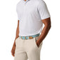 A man wearing a Johnnie-O Tee Time Polo, featuring moisture-wicking lightweight fabric, and beige pants with a blue patterned belt stands against a white background.