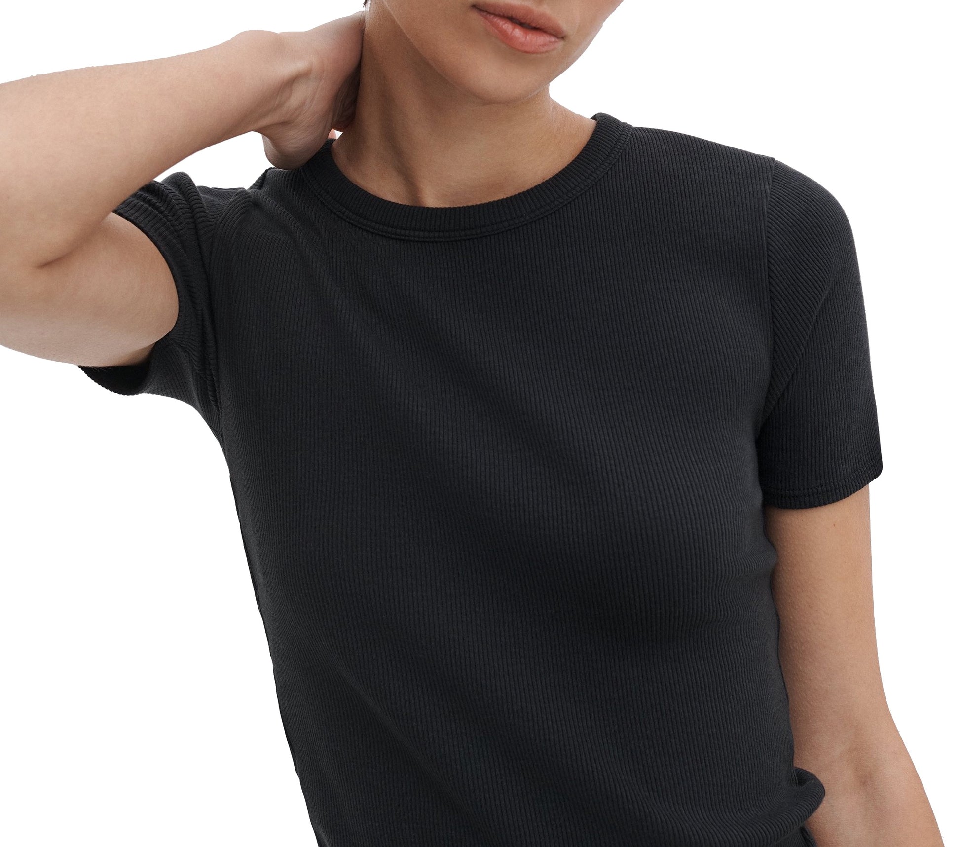A person stands against a white background, one hand on their neck, wearing the Rag & Bone Essential Ribbed Tee—a true wardrobe staple.