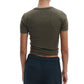 Model shown from the back in Rag & Bone's Essential Ribbed Tee, fitted and short-sleeved in olive green, paired with navy blue pants with white side panels—timeless wardrobe staples against a white background.