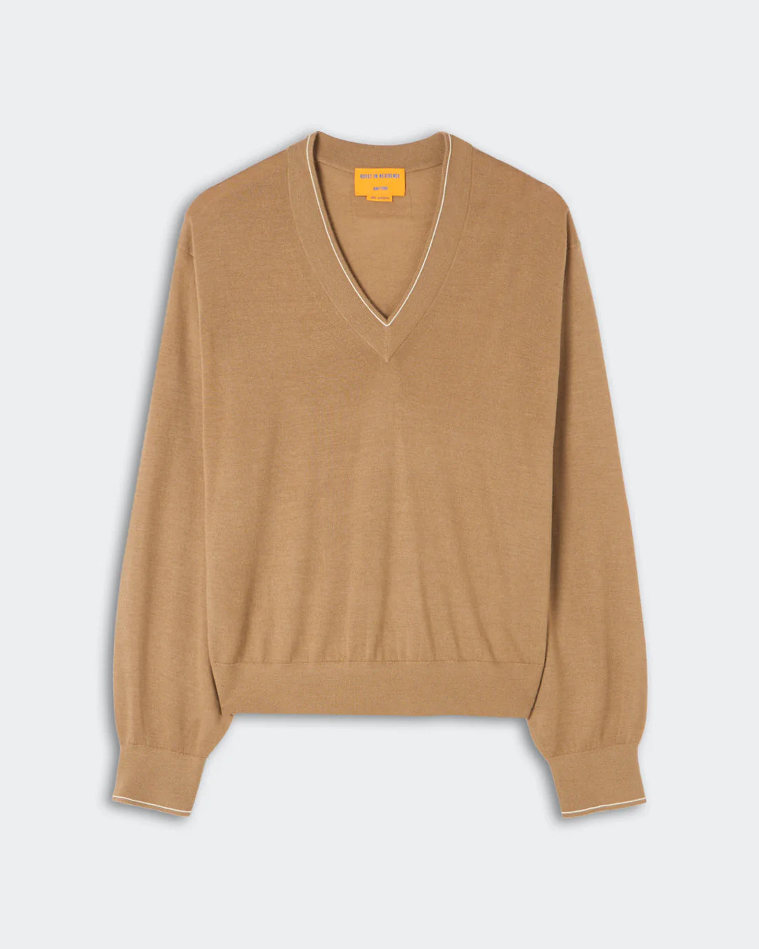 The Airy V by Guest in Residence—a tan lightweight cashmere V-neck sweater featuring long sleeves, ribbed cuffs and hem, and subtle contrast trim—perfect for effortless summer layering; shown laid flat against a plain light background.