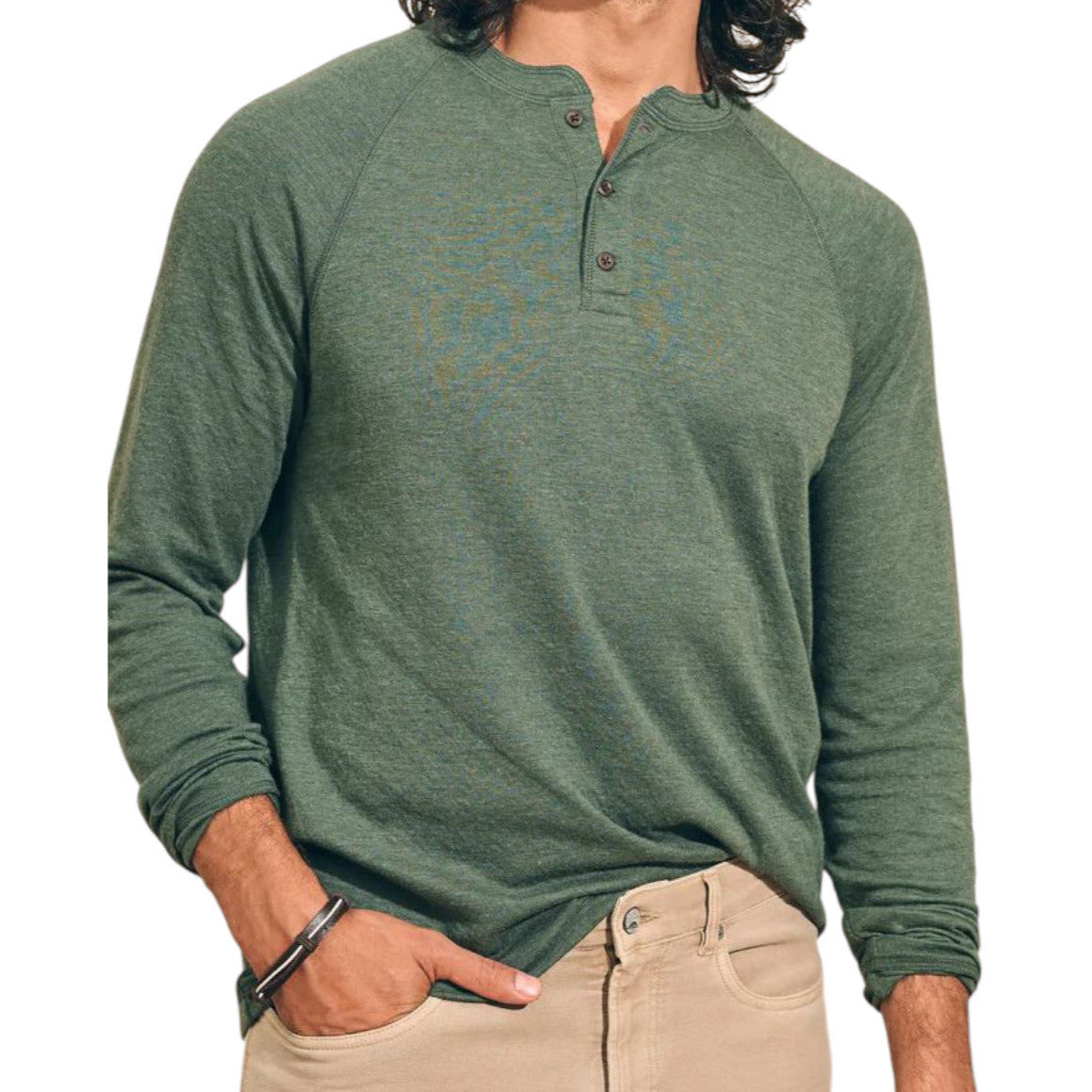 A person wearing a Faherty Long-Sleeved Cloud Henley in green with three buttons and beige pants, shown from shoulders to hips.
